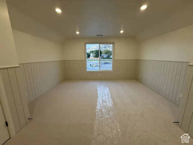 Recessed ceiling lighting, a large window, carpeted flooring, and wainscoting