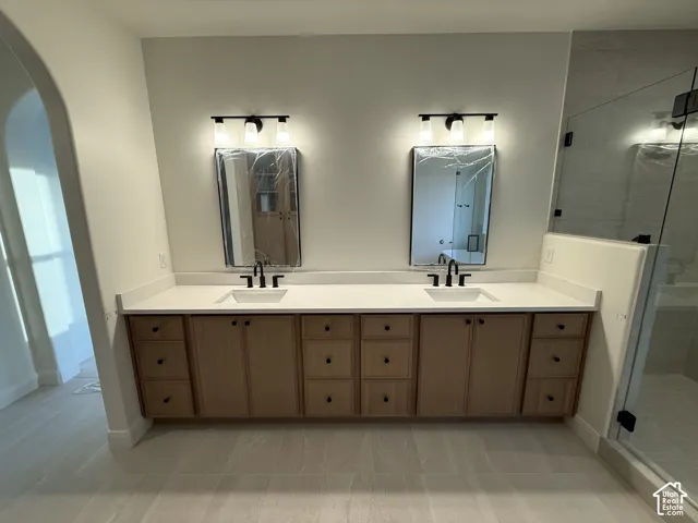 Dual vanities with white countertops, undermount sinks, and matte black fixtures