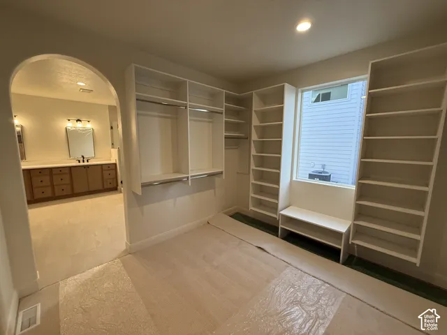 Built-in shelving and hanging rods, recessed lighting, and a window with a built-in bench