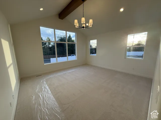 Primary Bedroom featuring Vaulted ceiling with an exposed wood beam, large multi-pane windows, recessed lighting, and a contemporary chandelier
