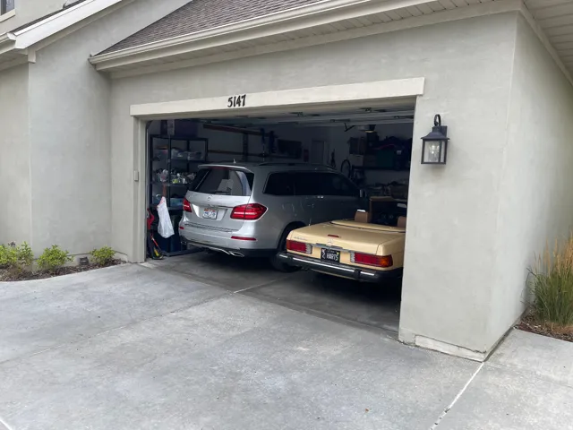 Two-car garage with stucco exterior and concrete driveway