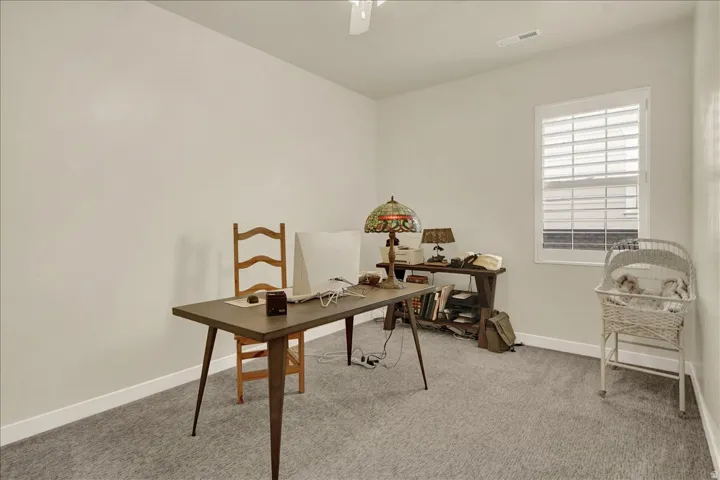 Carpeted room with a ceiling fan, white walls, and a white window with horizontal blinds