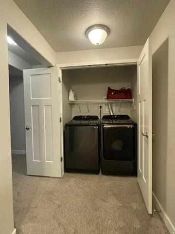 Laundry closet featuring a wire shelving unit, overhead lighting, and panel doors