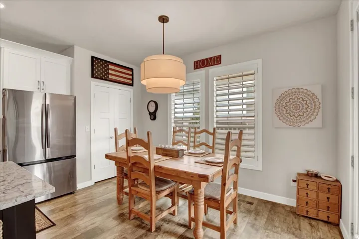 Dining area featuring wood-finish flooring and a central chandelier