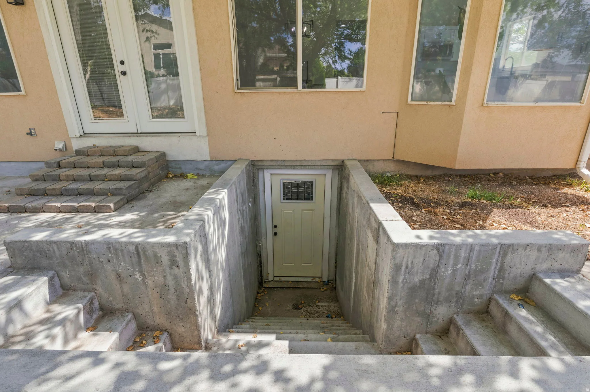 Exterior entry featuring a private concrete stairwell leading to a dedicated door