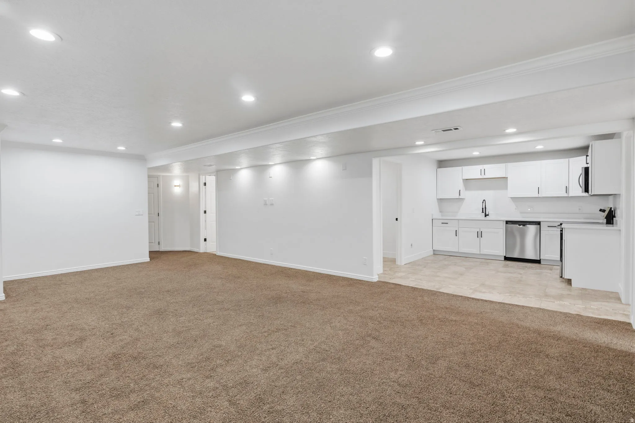 Open-concept living area featuring plush carpeting and recessed lighting