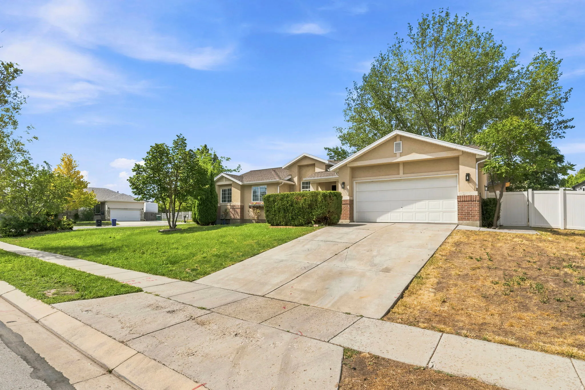 Two-story property featuring a stucco and brick exterior, an attached two-car garage, and a concrete driveway