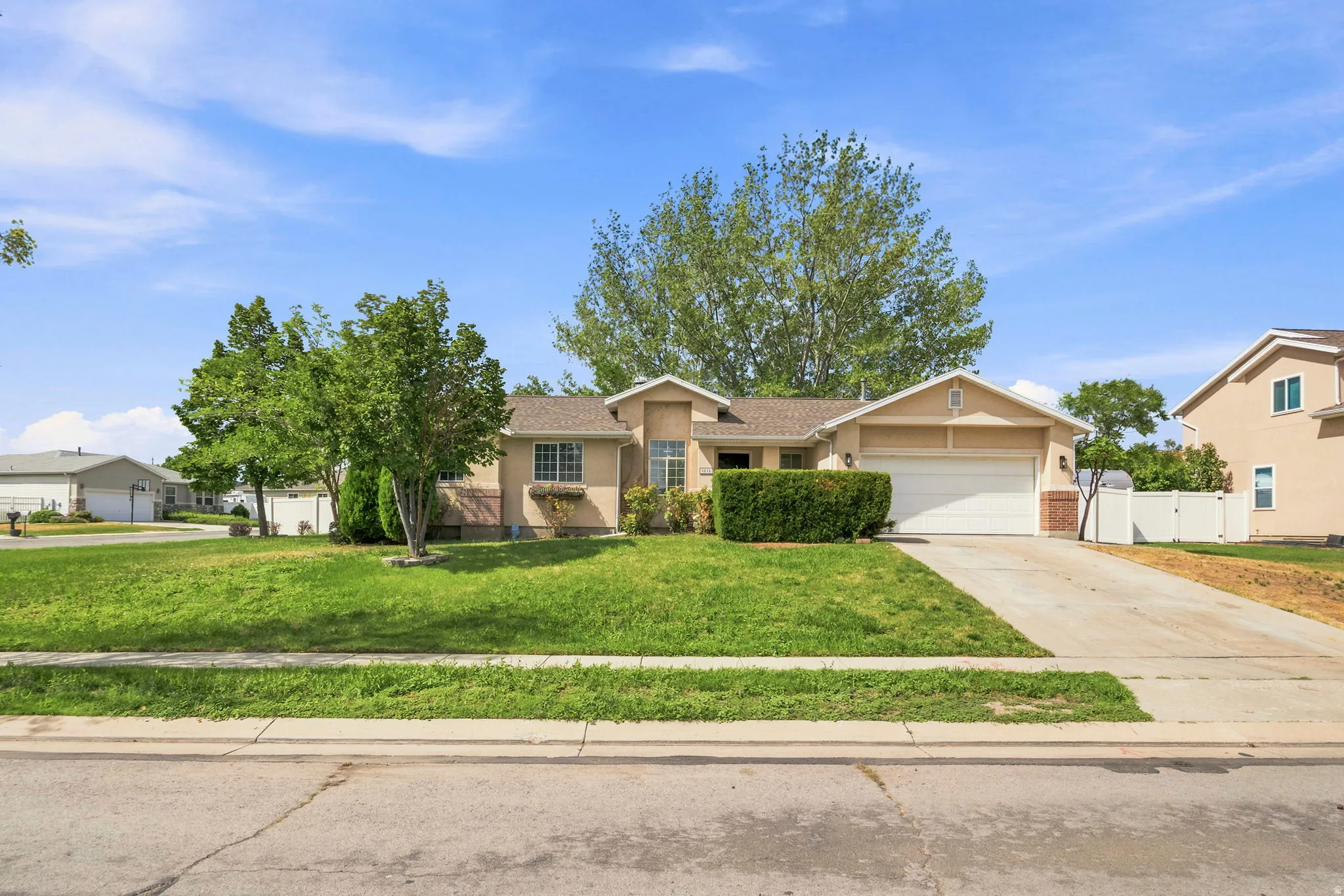 Single-story home featuring a stucco exterior, attached garage, and a concrete driveway