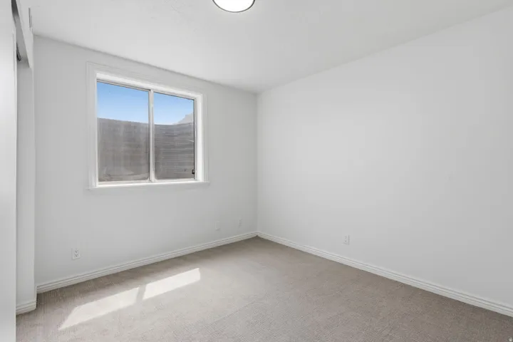 Recessed lighting, white walls, gray carpet, white trim, and a sliding window