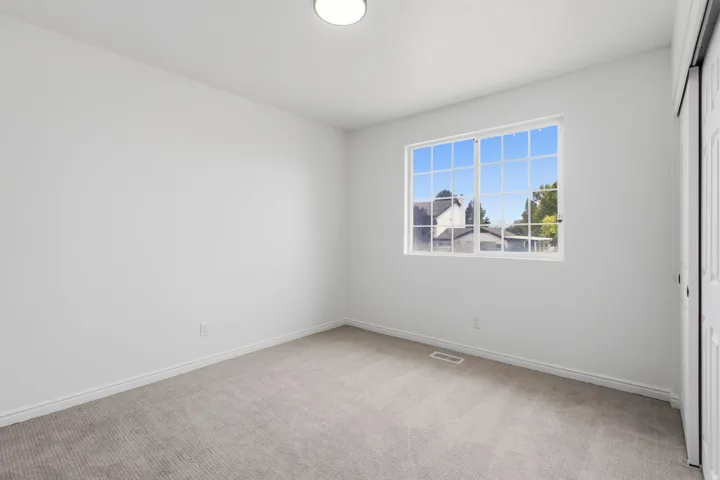 Neutral wall finishes, recessed lighting, grid-pattern window, and gray carpet flooring