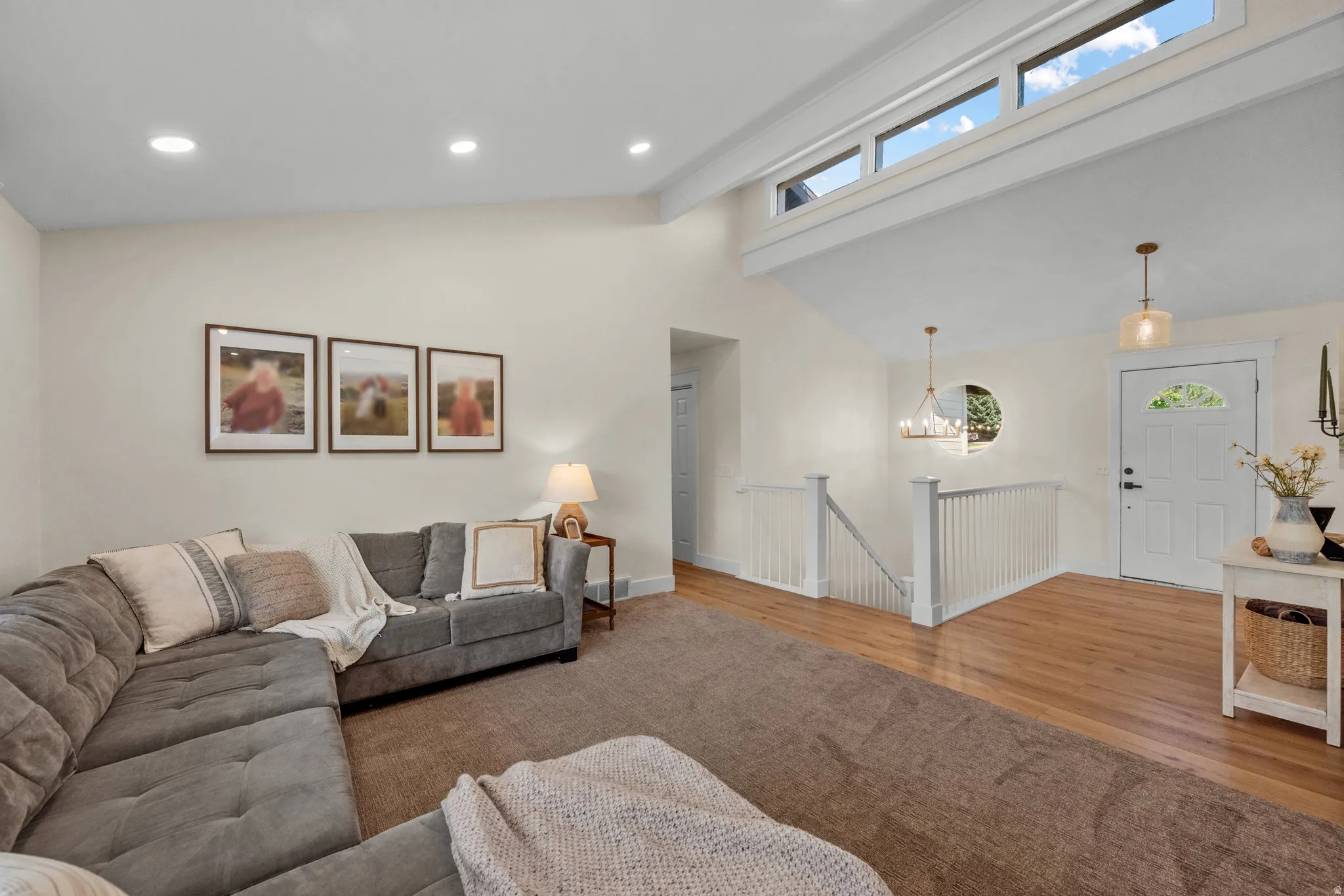 Spacious living area featuring high vaulted ceilings, recessed lighting, and upper transom windows