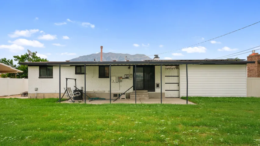 Rear exterior featuring a covered patio, sliding glass door entry, and two rear windows