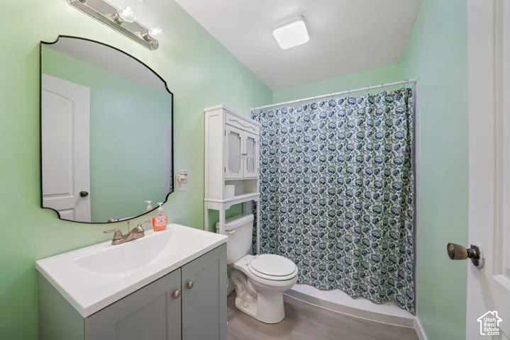 Bathroom featuring a single vanity with integrated sink, a contemporary mirror, and a full shower with a patterned curtain