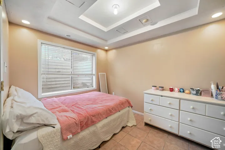 Room featuring a tray ceiling with recessed lighting and a central light fixture