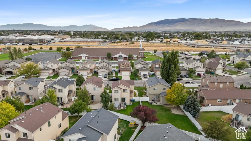 Aerial perspective of a residential community featuring detached homes with varied architectural styles and roof colors