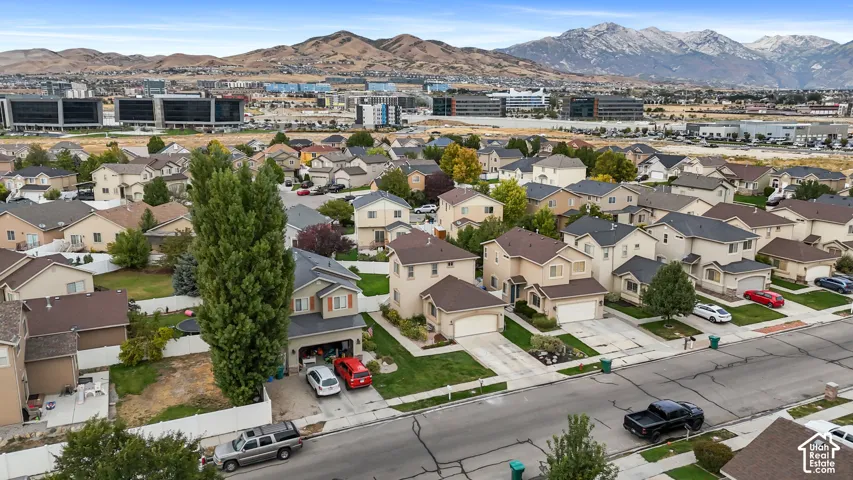 Suburban neighborhood featuring residential homes with attached garages, paved driveways, and manicured lawns