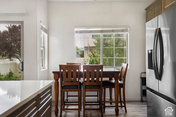 Dining area featuring a grid-pattern window, wood-finish flooring, and a sliding glass door