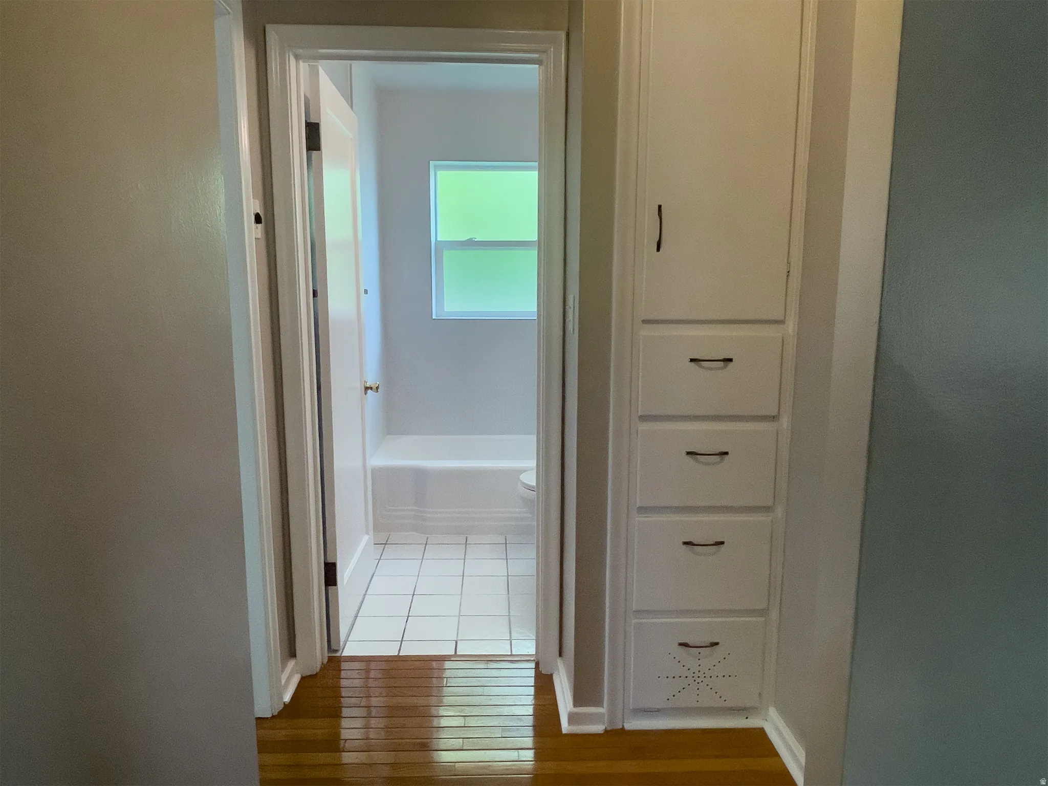 Hallway featuring built-in storage cabinetry with multiple drawers and a floor-to-ceiling cabinet