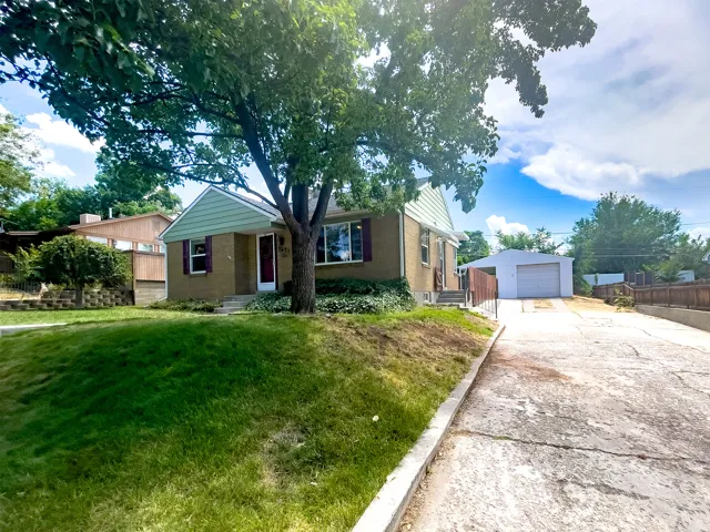 Traditional-style residence featuring a brick facade with light green siding and a front entry with a red door
