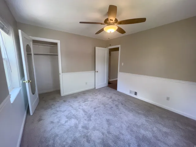Room featuring light gray carpeting and a neutral wall color with white wainscoting