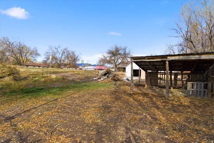 Expansive land parcel featuring a rustic wooden lean-to structure and varied terrain