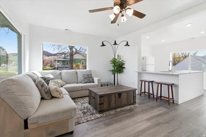 Open concept living area featuring wood-finish flooring and ample natural light from large windows