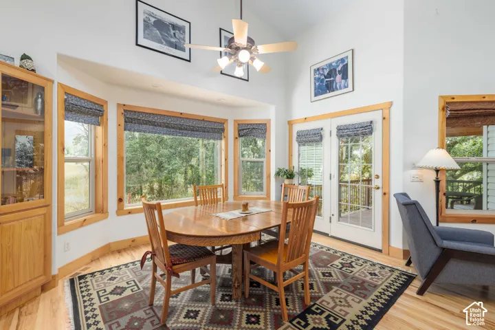 Dining area featuring natural wood trim, a built-in display cabinet, and a vaulted ceiling with a ceiling fan