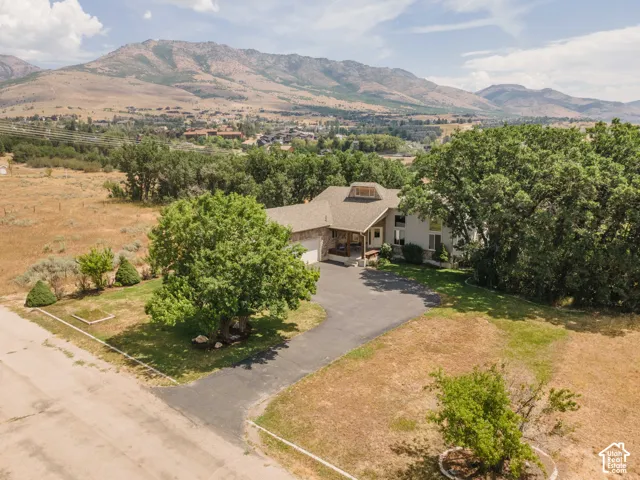 Custom home featuring a covered front porch, an attached two-car garage, and a dormer window