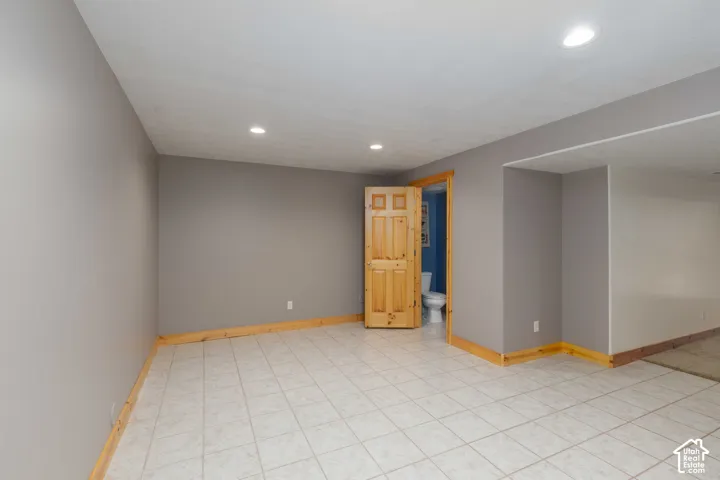 Recessed lighting, tile flooring, wood trim, wood-paneled door