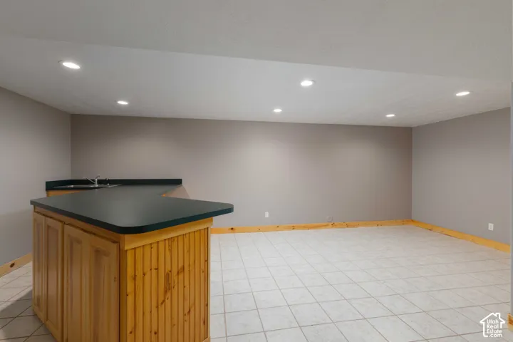 Spacious room with tile flooring and recessed lighting
