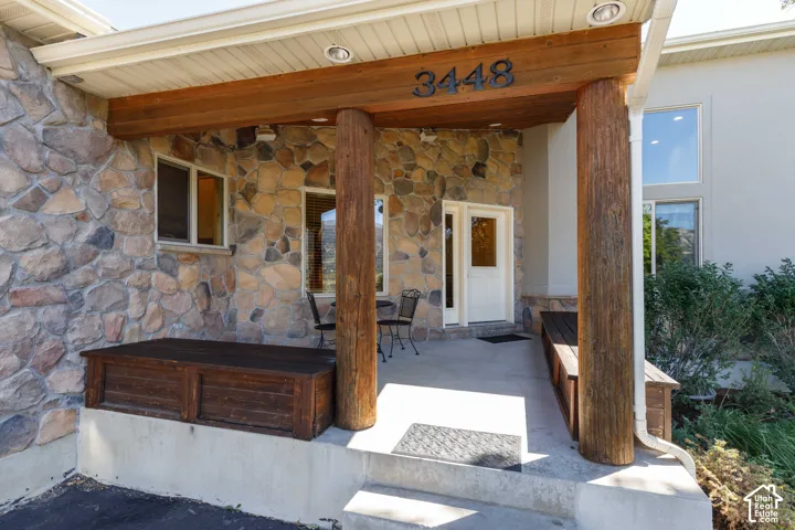 Stone façade with wood-wrapped columns and a covered porch