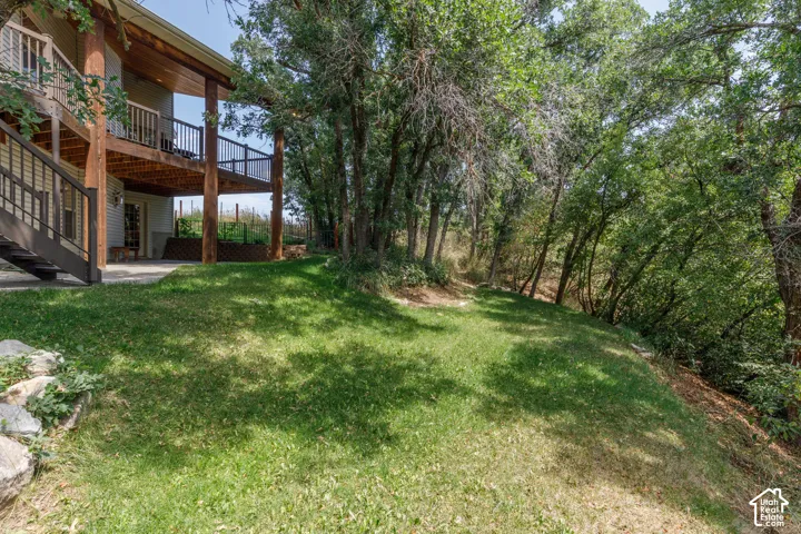 Tiered outdoor living spaces featuring a ground-level patio and an upper-level covered deck with dark wood railing