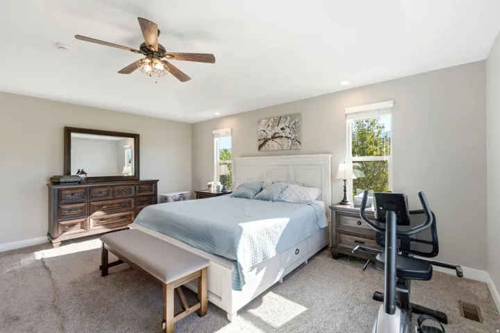 Tray ceiling with a ceiling fan, recessed lighting, and carpeted flooring