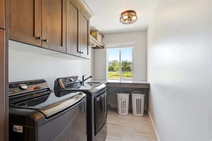 Main Level Laundry ,wood-finish cabinetry, utility sink,