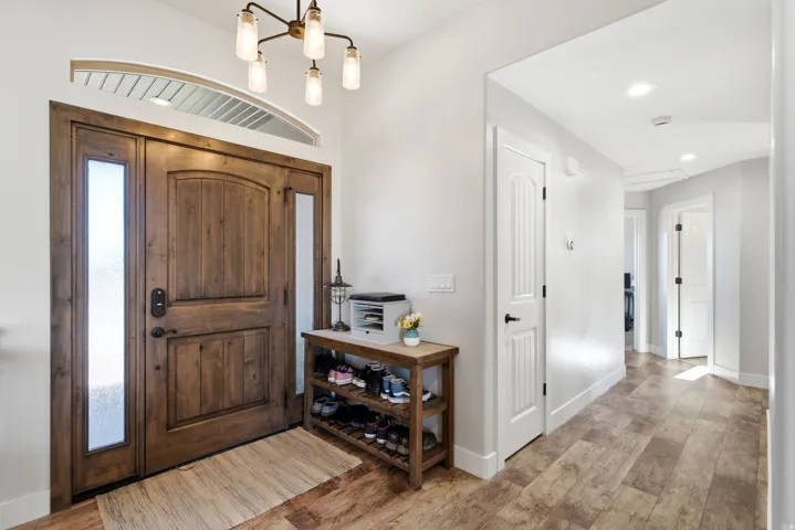 Rich wood-finish entry door with frosted sidelights and an arched transom window