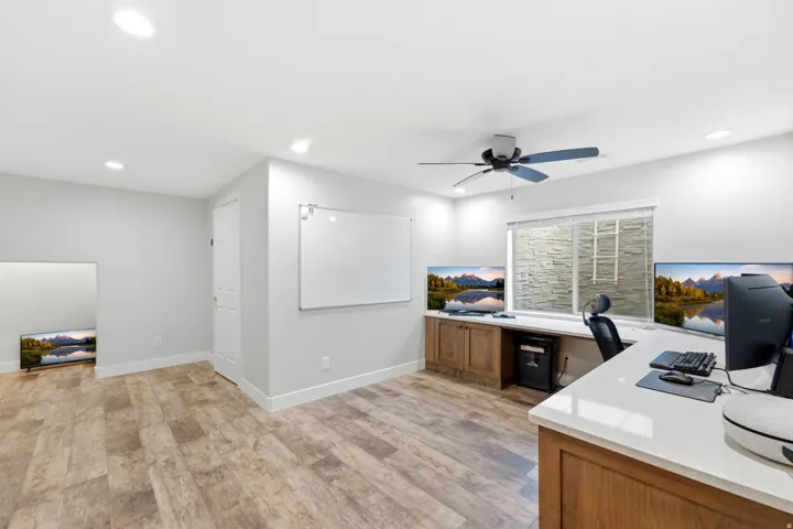 Recessed lighting with a ceiling fan, wood-finish flooring, and built-in cabinetry with a white countertop