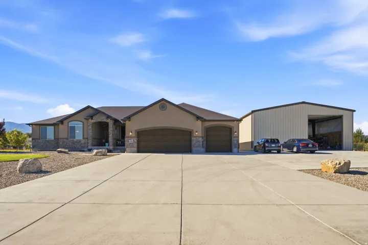 Stucco exterior with stone accents, covered entry, and attached two-car garage