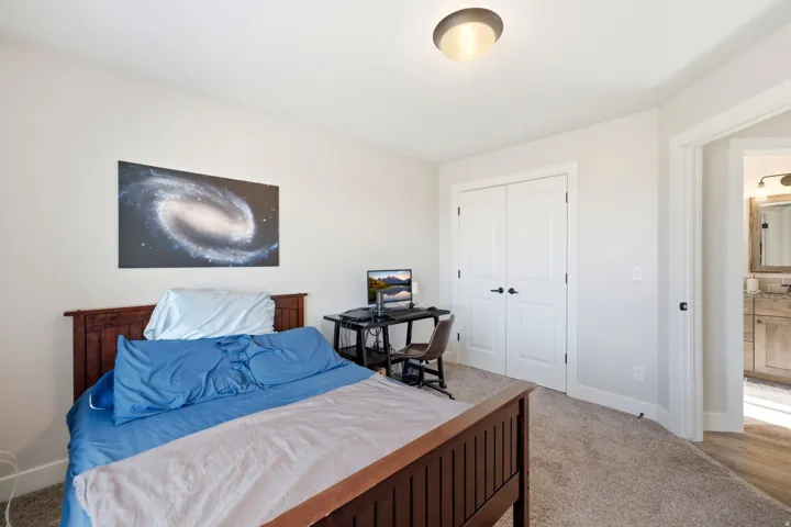Recessed lighting, light-colored walls, carpeted flooring, and white bifold closet doors with dark hardware