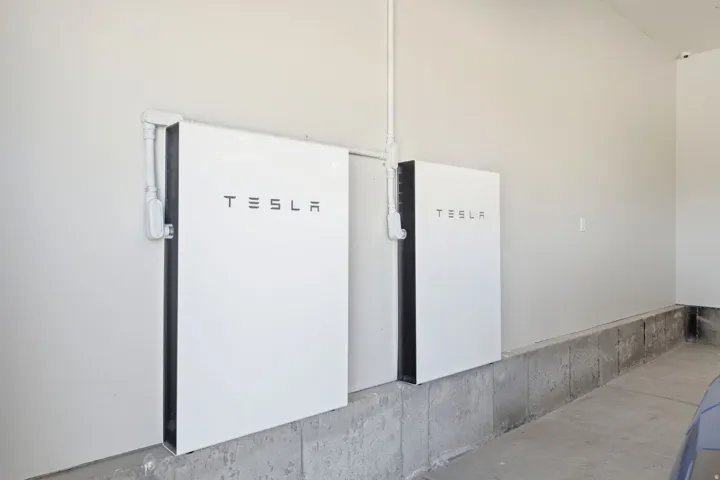 Two wall-mounted Tesla Powerwall units with conduit wiring