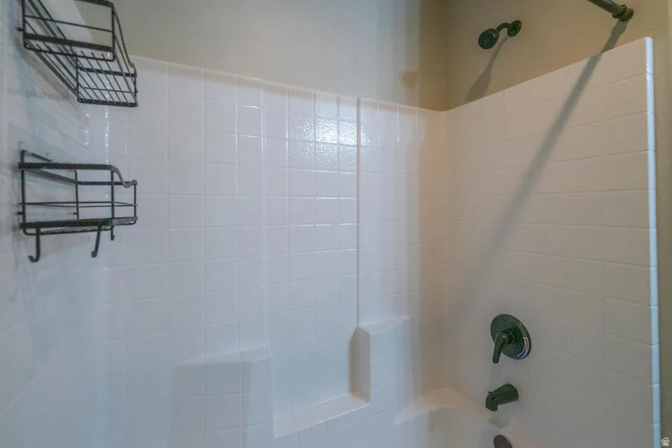 Bathtub with tiled surround and dark bronze fixtures