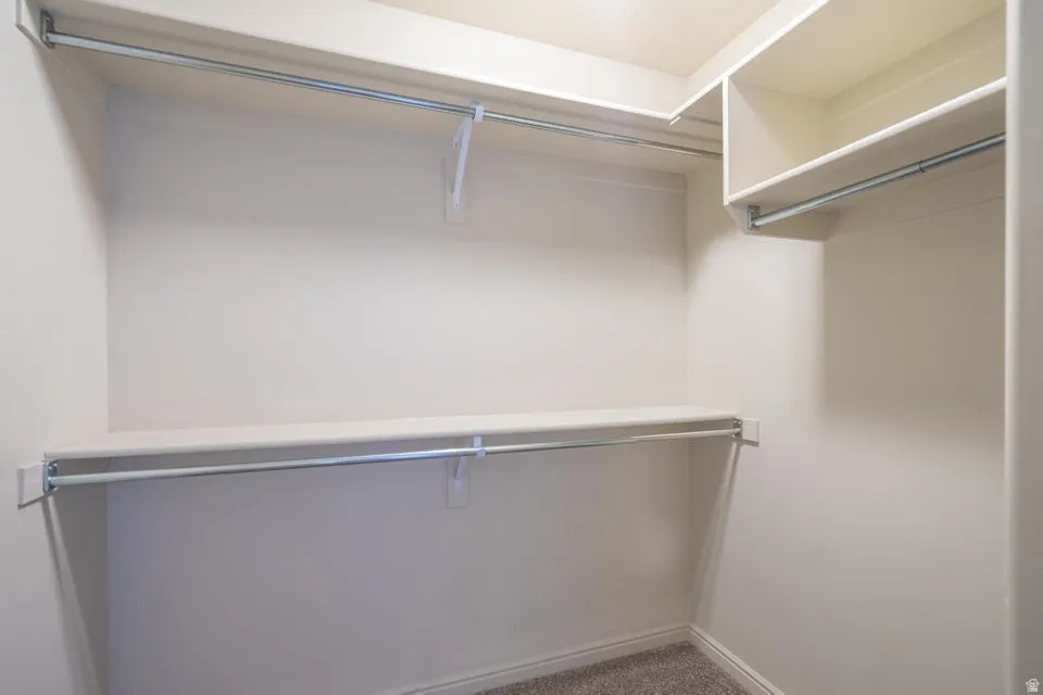 Spacious closet featuring multiple shelves and hanging rods