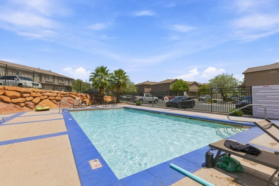 Rectangular swimming pool featuring blue tiled coping and a light-colored concrete surround