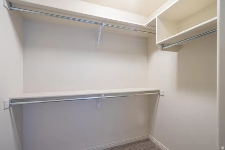Spacious closet featuring multiple shelves and hanging rods
