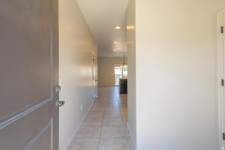 Entryway featuring neutral wall tones, recessed lighting, and tile flooring