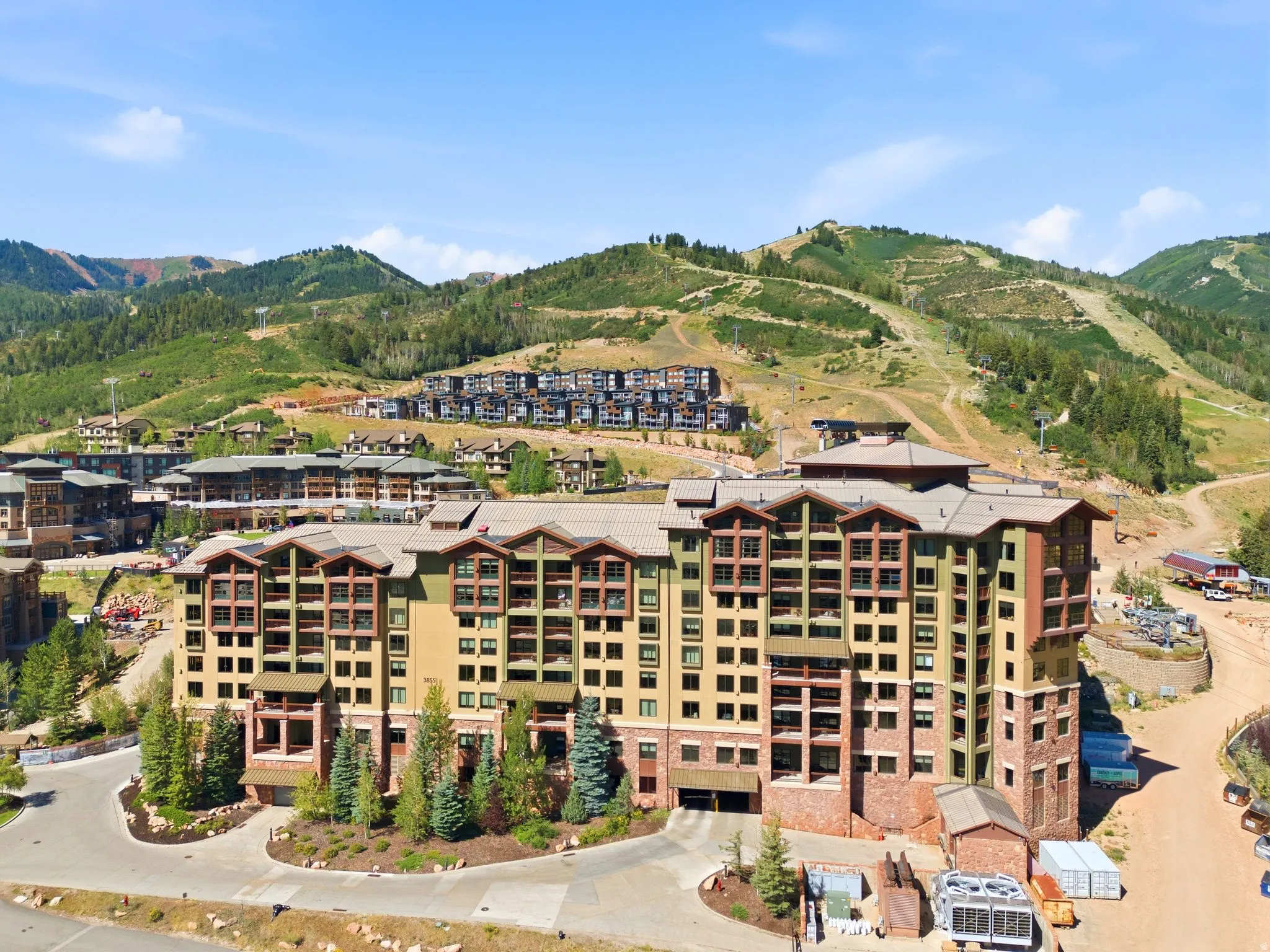 Multi-story residential building featuring a stone and siding exterior, sloped rooflines, and multiple balconies