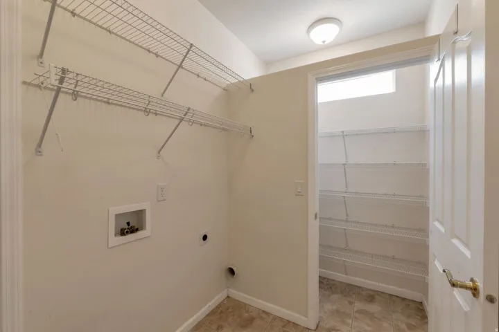 Laundry area featuring wire shelving, utility hookups, and ceramic tile flooring