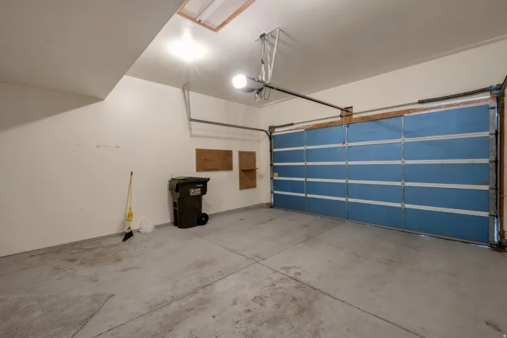 Interior garage space featuring a paneled overhead door, concrete flooring, and an automatic garage door opener