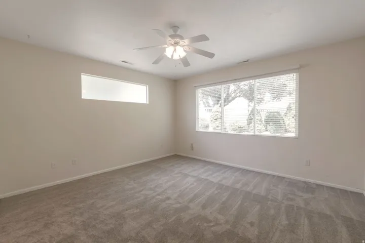 Spacious room featuring neutral carpeting and light-toned walls