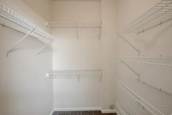 Spacious closet featuring white wire shelving and hanging rods