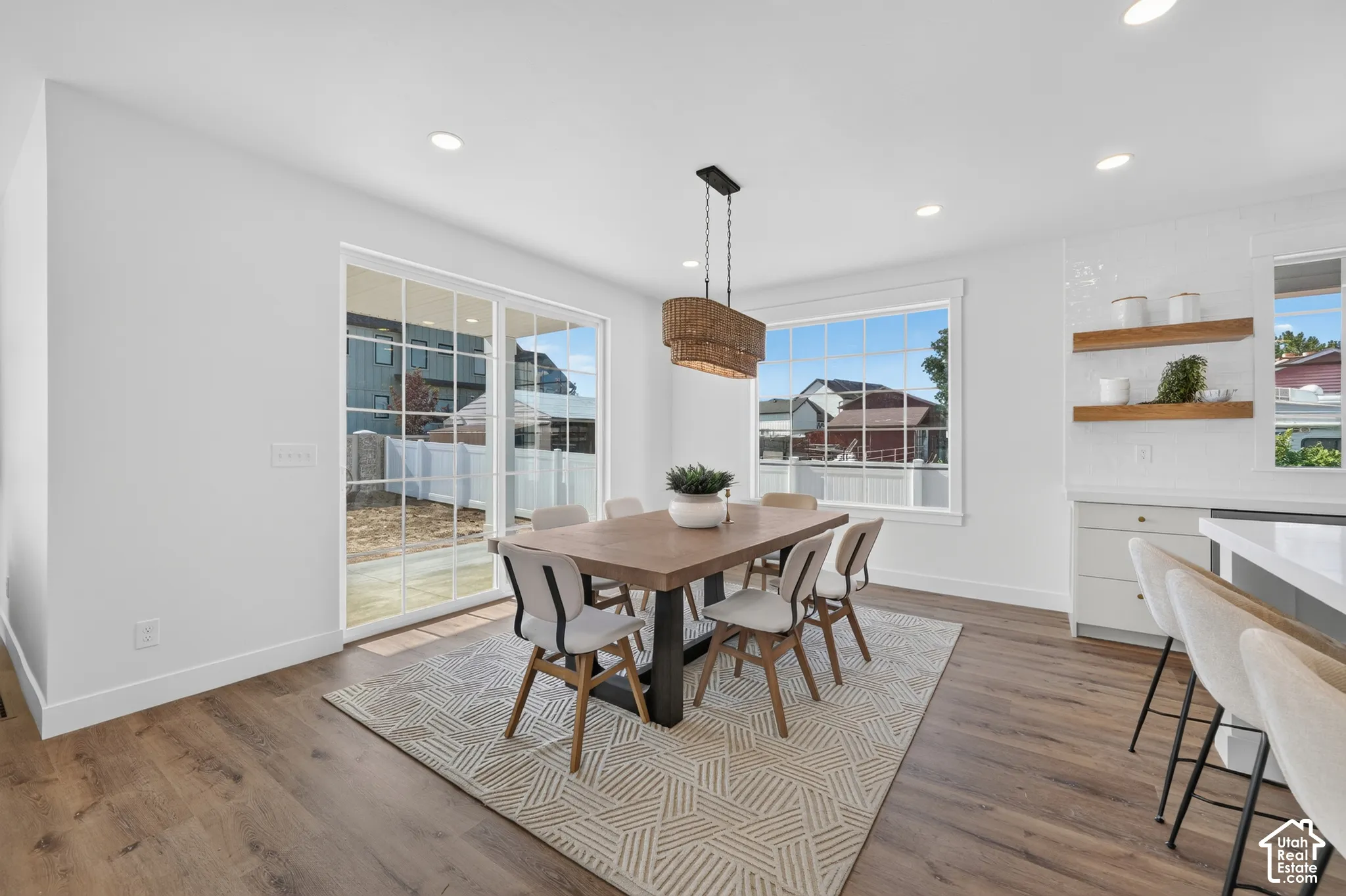 Open-concept dining area featuring wood-finish flooring, recessed lighting, and a woven pendant light fixture